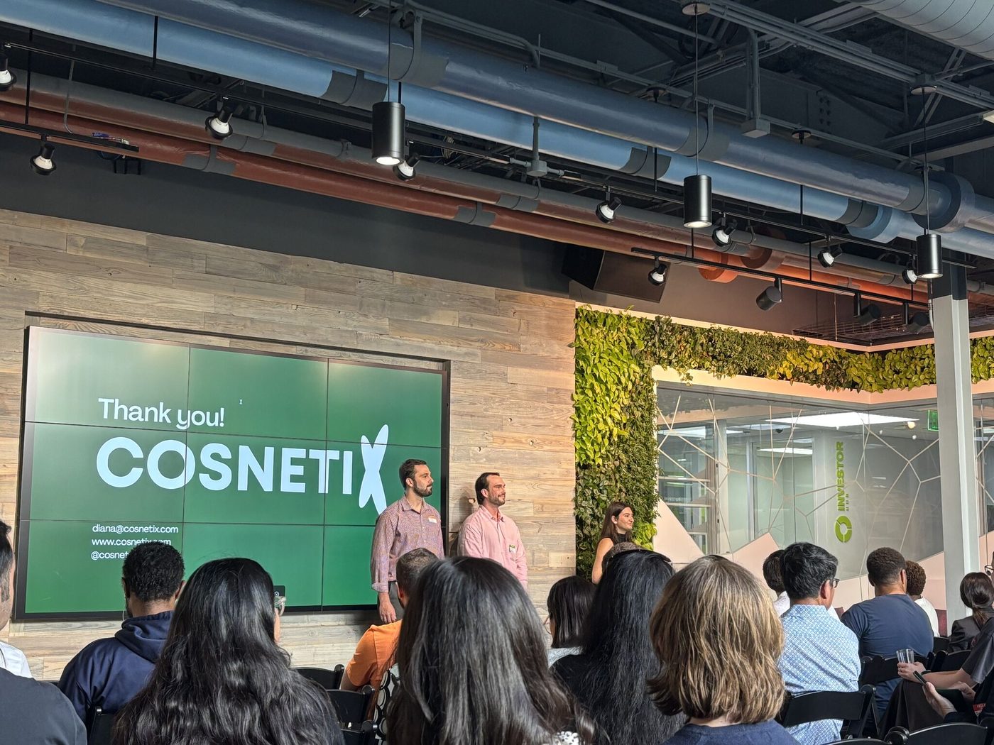 The Cosnetix founders on stage after a pitch, in front of a Thank You slide